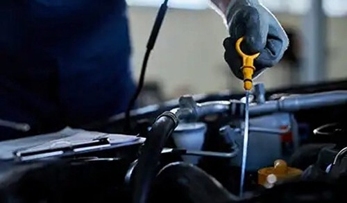 Checking the oil level using the engine dipstick