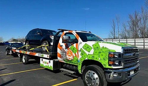 Sell My Junk Car flatbed towing a black SUV.