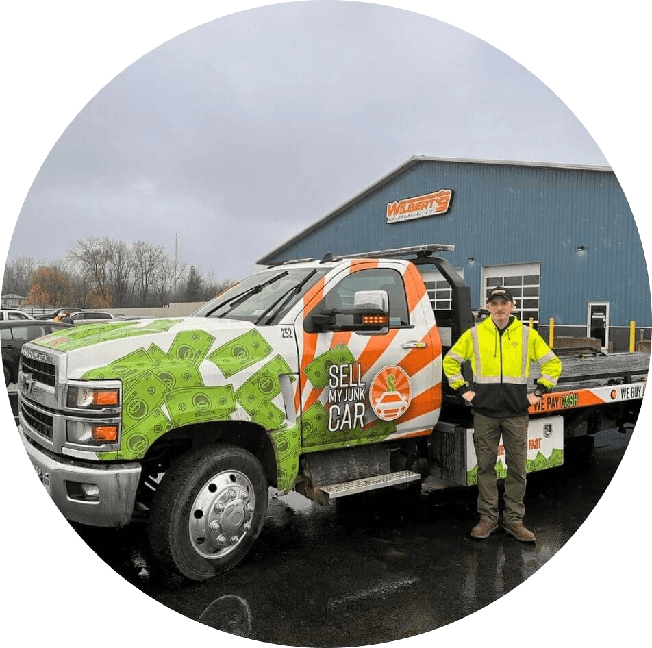 Tow truck driver Coleton standing by Sell My Junk Car truck.